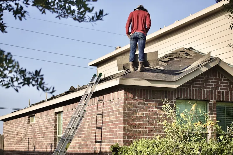 Professional roofer working on a residential roof in West Concord